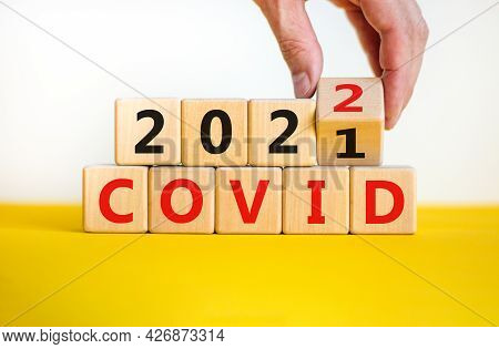 Covid-19 Pandemic In 2022 Symbol. Doctor Turns A Wooden Cube And Changes Words 'covid 2021' To 'covi