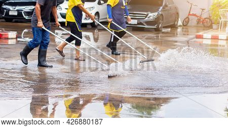 Selective Focus To Worker Using Wiper Or Squeegee To Clean Floor Surface. Staff Cleaning Floor With 