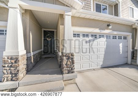 Front Exterior Of A House With White Sectional Garage Door With Window Panels