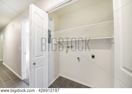 Empty White Laundry Closet With Bifold White Doors
