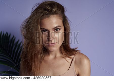 Pretentious, Serious Female Model In A Purple Studio With A Tropical Palm Leaf. Brunette Beautiful F