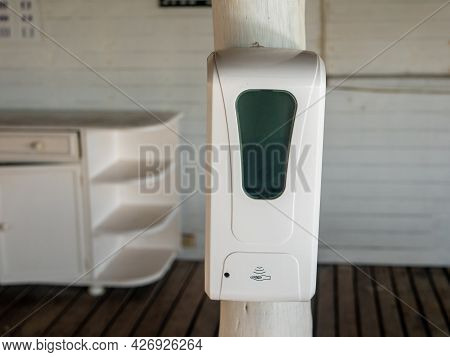 Non-contact Hand Sanitizer Disinfector A Plastic Case. White Sanitizer Was Attached To A Pole In A H