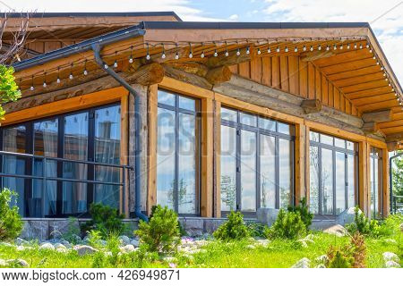 Beautiful Wooden House With Large Stained Glass Windows On The Background Of The Summer Sky