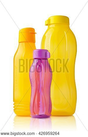 Plastic Tupperware Bottles. Stack Of Colorful Plastic Bottles For Drinking With Ergonomic Lid Isolat