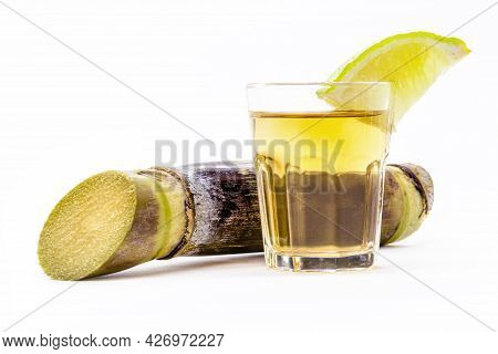 Brazilian Pinga Cup On Isolated White Background With Sugar Cane On The Side.