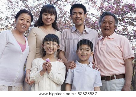 Portrait of a smiling multi-generational family amongst the cherry trees