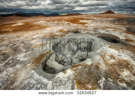 Mudpots in the geothermal area Hverir, Iceland. The area around the boiling mud is multicolored and cracked. HDR image