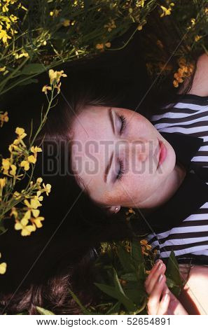 Girl's beautiful face with yellow flowers and green gross