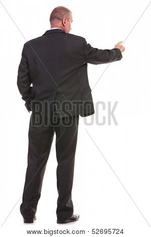 full length back view picture of a business man pushing an imaginary button while holding his other hand in his pocket. on a white background