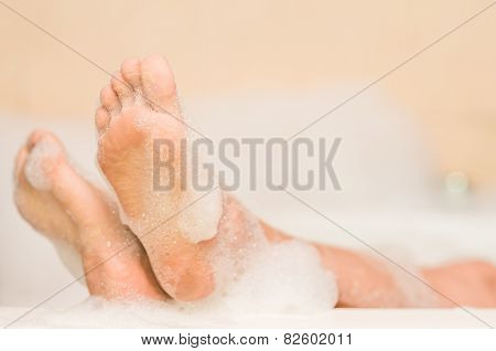 closeup of woman's feet covered with foam bubbles