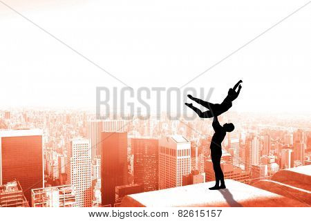 Ballet partners dancing gracefully together against high angle view of city