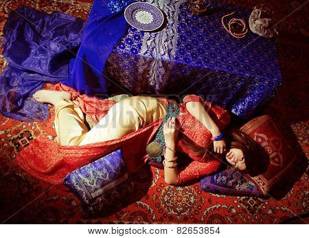 young pretty asian girl in bright colored interior on carpet