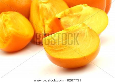 zwei Persimmon-Frucht und eine in Scheiben geschnitten