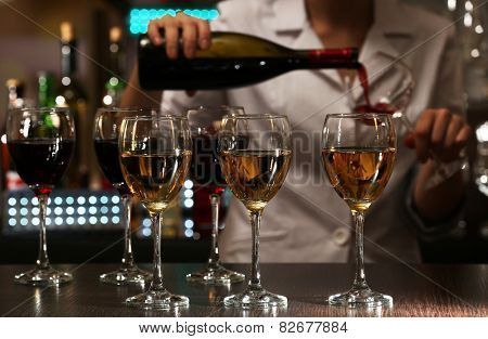 Bartender working at counter on bar background