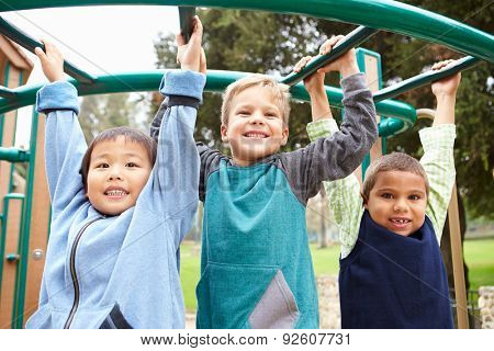 Three Young Boys On Climbing Frame In Playground