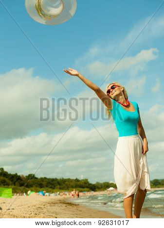 Girl Trowing Hat Up On Beach