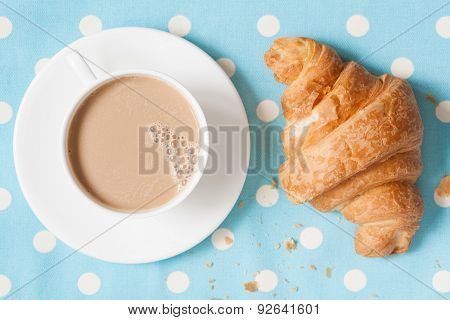 Cup of coffee latte and croisssant, traditional French viennoiserie dessert on provence style backgr