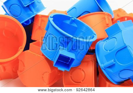 Heap Of Orange And Blue Electrical Boxes On White Background