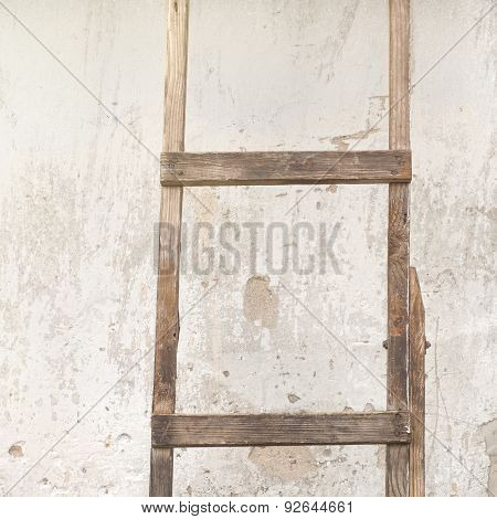 weathered stucco wall with wooden ladder