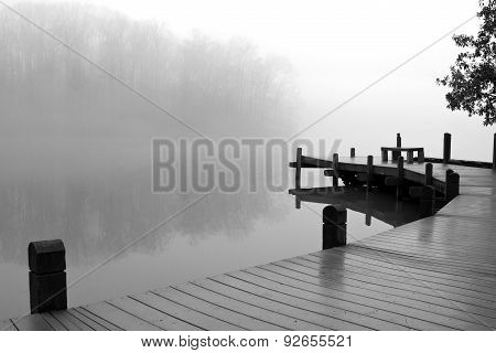 Thick Fog Covers Wooden Dock And Lake On Winter Day