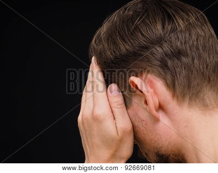 Male Caucasian Person Covering Face With One Hand Isolated Towards Black