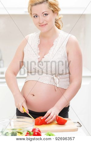 Pregnant woman cooking salad