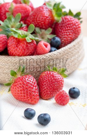 still life of strawberries and raspberries accompanied by berries