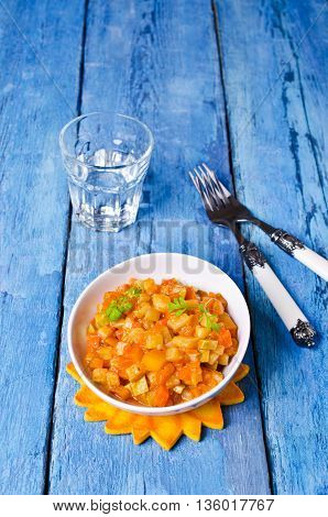 Vegetable stew with sauce on wooden background. Selective focus.