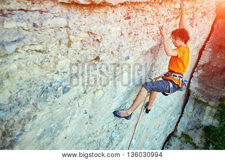 male rock climber. rock climber climbs on a rocky wall. man makes hard move