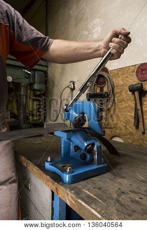 Worker operating old metal sheet press machine