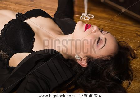 Woman In A Black Suit With Gun Lying On The Floor