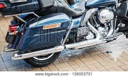 Blue classic motorcycle at parking in the rain