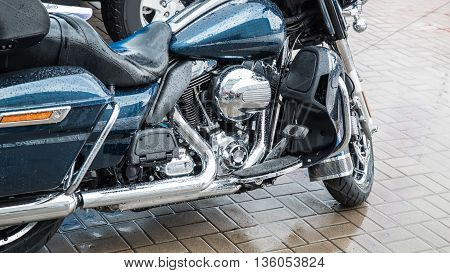 Blue classic motorcycle at parking in the rain