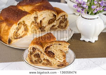 Good piece of typical italian flavorous home baked cake La Gubana with sophisticated stuffing (hazelnuts fruit chocolate walnut raisins honey etc.) with purple flowers of salvia. Traditionally bake for Christmas and Easter.