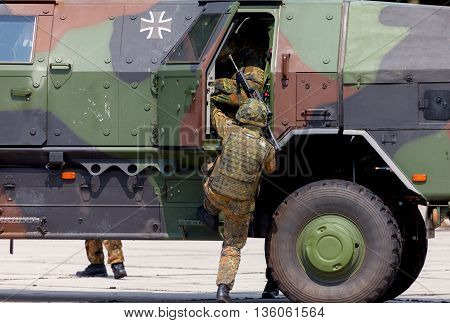 BURG / GERMANY - JUNE 25 2016: german soldier is moving into military infantry vehicle Dingo on open day in barrack burg / germany at june 25 2016