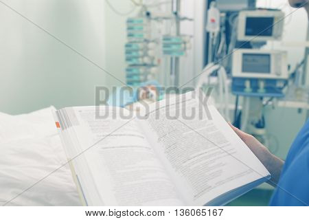 Reading medical book in patient ward. Medical student life