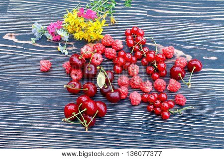 Ripe fresh clusters of red currant cherries and raspberry on the table