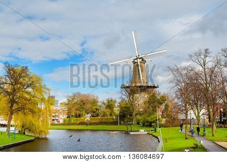 Leiden, Netherlands - April 7, 2016: Windmill de Valk in Leiden, street light and canal, Holland, Netherlands in spring