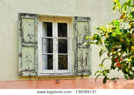Old  scratched white window with light green shutters