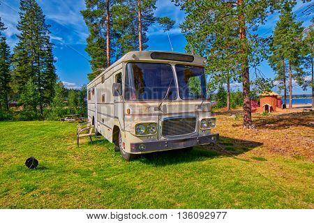 HUDIKSVALL, SWEDEN - CIRCA AUGUST 2015: Big Old American RV / Camping Car in Pine Forest Setting