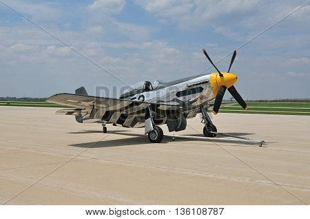 vintage fighter plane parked on the tarmac at a small airport