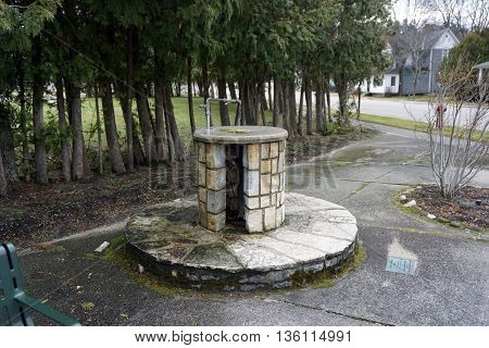 HARBOR SPRINGS, MICHIGAN / UNITED STATES - DECEMBER 24, 2015: Fresh water flows continuously through an artesian well at Tuttle Corner in Harbor Springs.