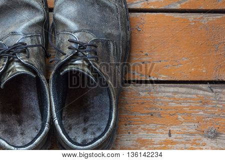the old genuine leather shoes on a wooden background