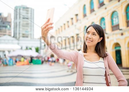 Woman self image by cellphone in Senado Square of Macau