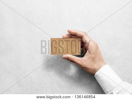 Hand hold blank plain craft business card design mockup. Brown calling card mock up template holding arm. Visit pasteboard kraft paper display front. Small offset texture card print. Logo branding