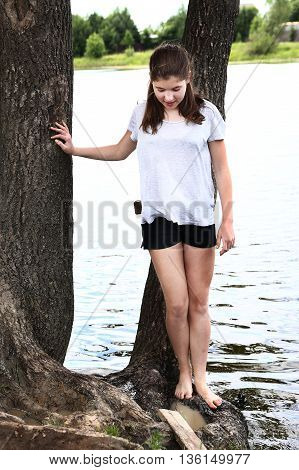 teenager girl try water in the lake with her foot