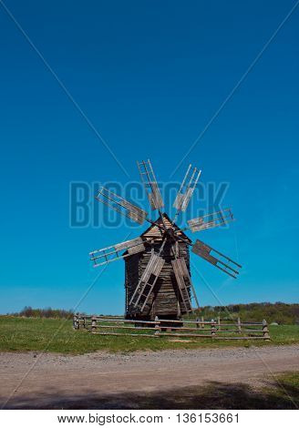 Landscape with old windmill next to the road in the village Pirogovo, Ukraine. Eastern Europe.