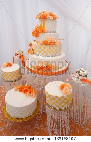 Wedding cakes big beautiful tasty many-tier decorated with orange flowers on white background