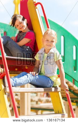 summer, childhood, leisure, friendship and people concept - happy kids on children playground climbing frame