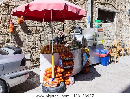 Acre Israel - May 28 2016: Street vendor of fresh fruit fresh juice and popcorn awaiting buyers in old city in Akre Israel